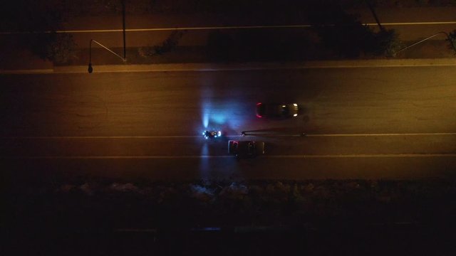 Police motorcyclists pursue and stop criminal car that driving on a road during dark night. Policeman checking document and driving license.