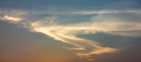 Obraz premium Clouds that are shaped like dragons flying in the sky or S form, at sunset background.