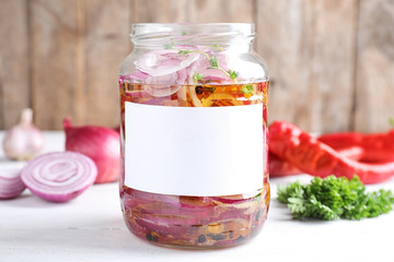 Jar of pickled onions with blank label on white table