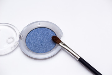 Blue eye shadows and eye brush  isolated on white background. Concept of makeup and beauty.
