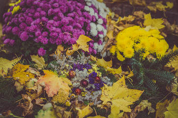 Fototapeta na wymiar wreath with colorful flowers during All Saints Day in the cemetery