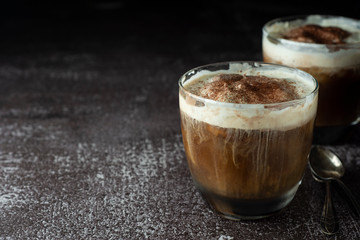 Affogato coffee with ice cream on a glass cup, dark, black background. Copy space.