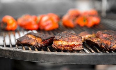 Close up of grilled meat with red pepper outdoor on grid