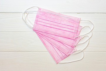 Protective medical mask of pink color on a white background.