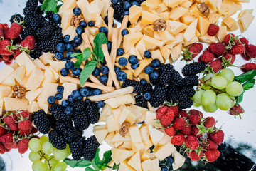 Food flat lay. Cheese plate served with wine, grapes, prosciutto, olives, snack table, jam and honey. Top view