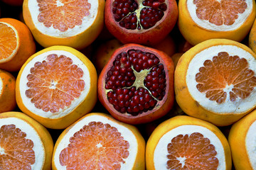 Fresh fruits orange pomegranate grapefruit laying on the market.  Close up tropical fruits background. Nice natural background with pomegranates, oranges and grapefruits in Istanbul Turkey.