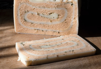 Craft cheese from cows and goats milk. Cheese head. Selective focus