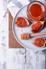 Pieces of figs drizzled with honey on white ceramic plate