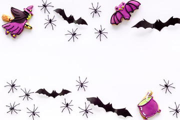 Cute Halloween decoration. Bats, spiders and special cookies on white background top view copy space