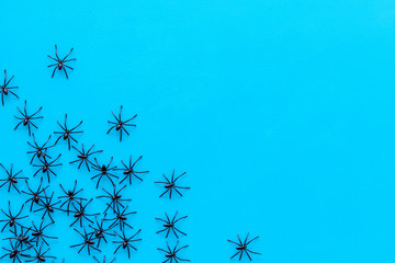 Minimalistic Halloween frame with small spiders on blue background top view space for text