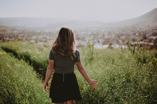 Girl touching green grass field during daytime