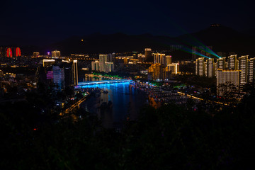 Night view of Phoenix island and Sanya city illuminated with city lights. View from Luhuitou Park on Hainan Island, China