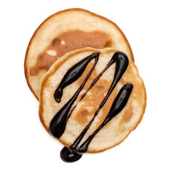 Two pancakes with chocolate syrup isolated on white background cutout. Top view.