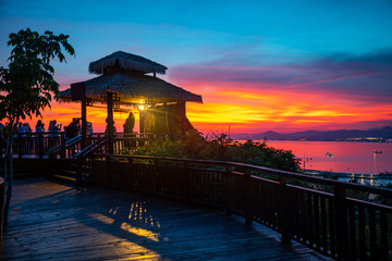 People on the observation deck against background of the sunset sky. View from Luhuitou Park on Hainan Island, China