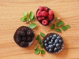 Mix of fresh berries on wooden background, blueberry, raspberry and blackberry