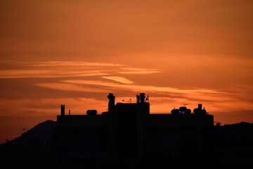 Fototapeta premium City image of red sky during sunset and buildings.
