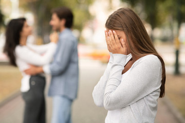 Upset woman crying, seeing her boyfriend with other girl