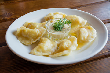 Dumplings on a white plate with sour cream. - Traditional Ukrainian food.