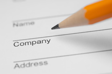 Filling in a form with a pencil, close up photo