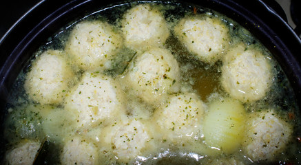 Close-up of a pan with soup and meatballs, cooking