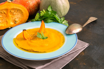 Vegetarian pumpkin cream soup on dark background.
