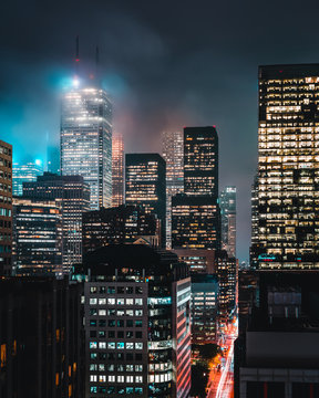 Grey clouds looming over the city buildings during nighttime