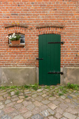 Grüne Tür mit Fenster und Blumen auf einem Bauernhof