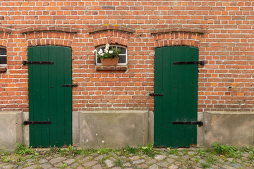Zwei gr&uuml;ne T&uuml;r mit Fenster und Blumen auf einem Bauernhof