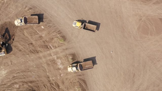 Aerial footage of a Vast excavation site with multiple heavy industry vehicles working