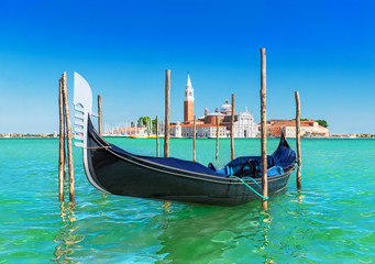 Venice seascape with gondola at wooden bricole mooring against famous San Giorgio Maggiore island and church in sunny day. View from from Piazza San Marco, Italy, Europe © EMrpize
