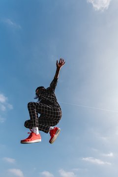 Woman jumping against cloudy sky