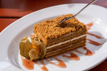 sweet honey cake on a wooden table in a cafe.