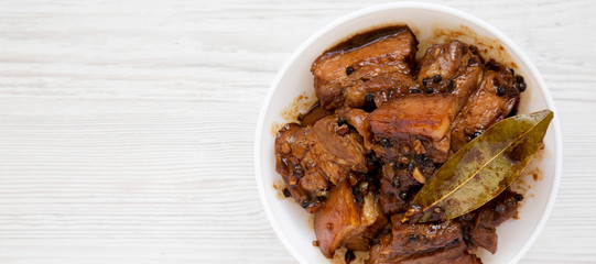 Homemade Filipino Adobo Pork on a white wooden background, top view. Flat lay, from above, overhead. Copy space.