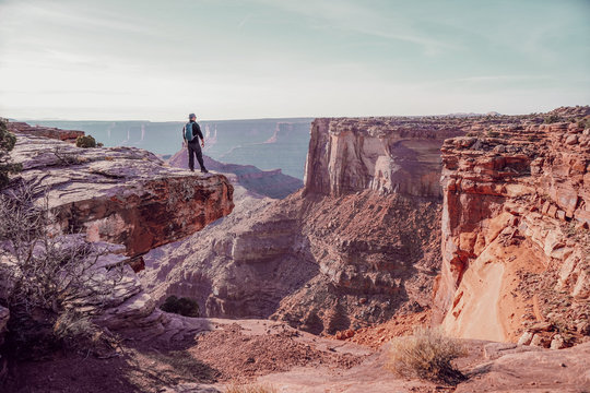 Person standing on the edge of cliff during daytime
