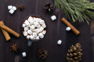 hot chocolate and mini marshmallow with christmas decoration on black background top view