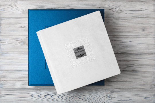 blue stylish square cardboard box for a photo album. Bright original box for white wedding album. leather photo book in the open box blue cardboard box for a photo book