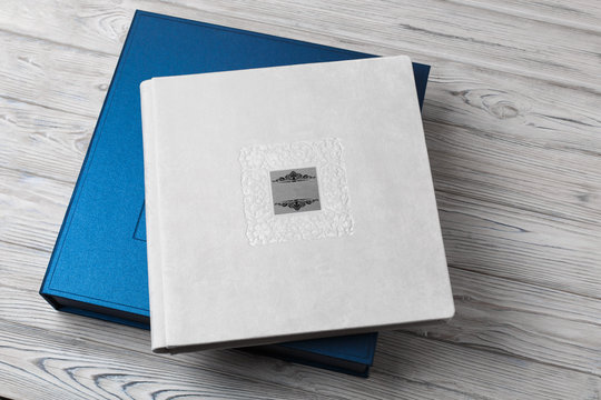blue stylish square cardboard box for a photo album. Bright original box for white wedding album. leather photo book in the open box blue cardboard box for a photo book