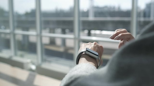 Woman using smartwatch touchscreen technology device. Smart watch on female wrist. Woman making gestures on a wearable smartwatch. Online banking. Lifestyle. Easy pay using digital device.
