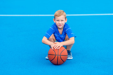 Adorable child playing the basketball in the basket field