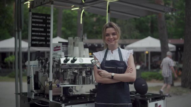 Beautiful barista woman during work in her movable street coffee shop