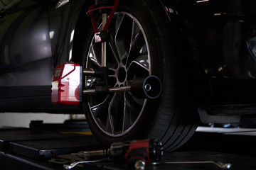 Fototapeta premium Closeup photoshoot of process or tyre balancing at dark auto service.