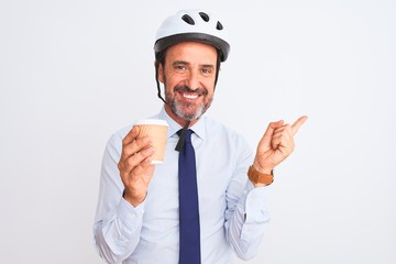 Middle age businessman wearing bike helmet drinking coffee over isolated white background very happy pointing with hand and finger to the side