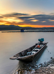 Fototapeta na wymiar Landscape a boat on the edge of a lake at beautiful sunset