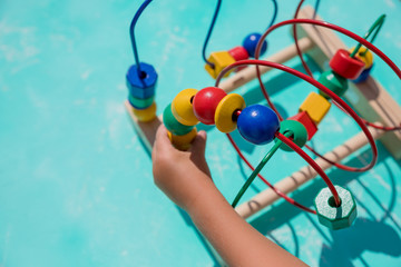 labyrinth with multi-colored puzzles on a wooden busy board- educational toy for children. A toy for entertaining children.Educational wooden Logic toy with paths in Toddler baby in nursery room.