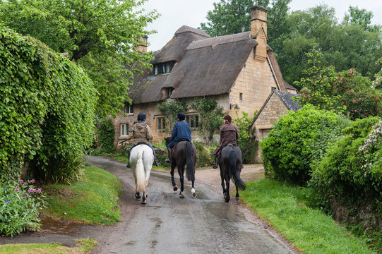 STANTON, ENGLAND - MAY, 26 2018:  Unidentifed people and horses near cottages in the village of Stanton, Cotswolds district of Gloucestershire.  