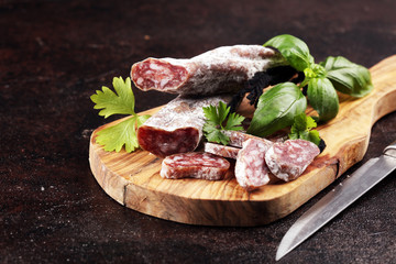 salami cut. thinly sliced salami on a wooden texture on the background.