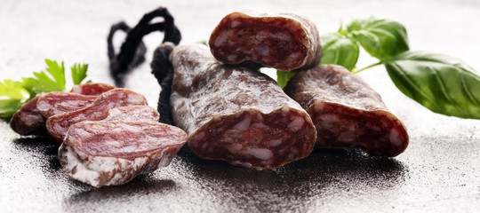 salami cut. thinly sliced salami on a wooden texture on the background.