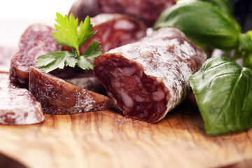 salami cut. thinly sliced salami on a wooden texture on the background.