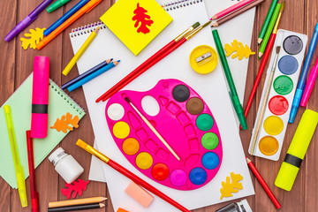 Naklejka premium Back to school concept. School education supplies on brown wooden boards background