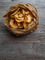 Homemade dried organic apple sliced on wood background, healthy snack concept